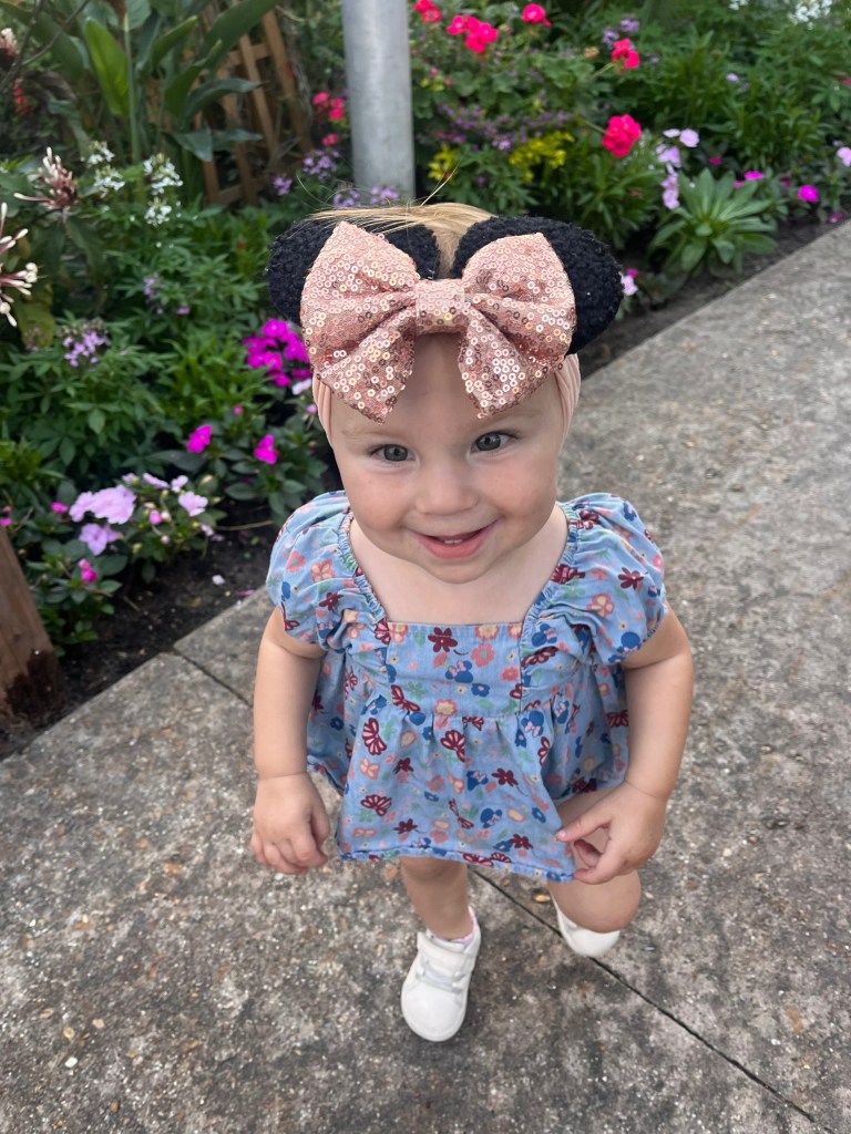 Baby girl with minnie ears headband in butterfly landing at EPCOT Flower & Garden Festival. 
